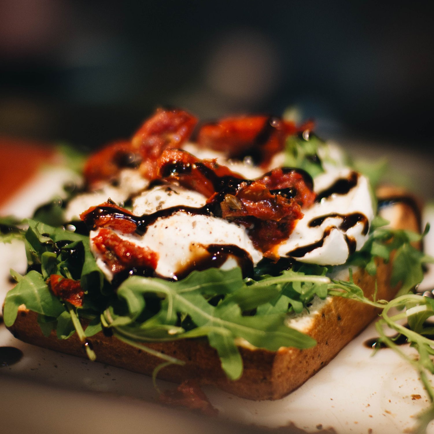 Open broodje bal Italiaans met mozzarella, gepofte tomaat, rucola en balsamicostroop